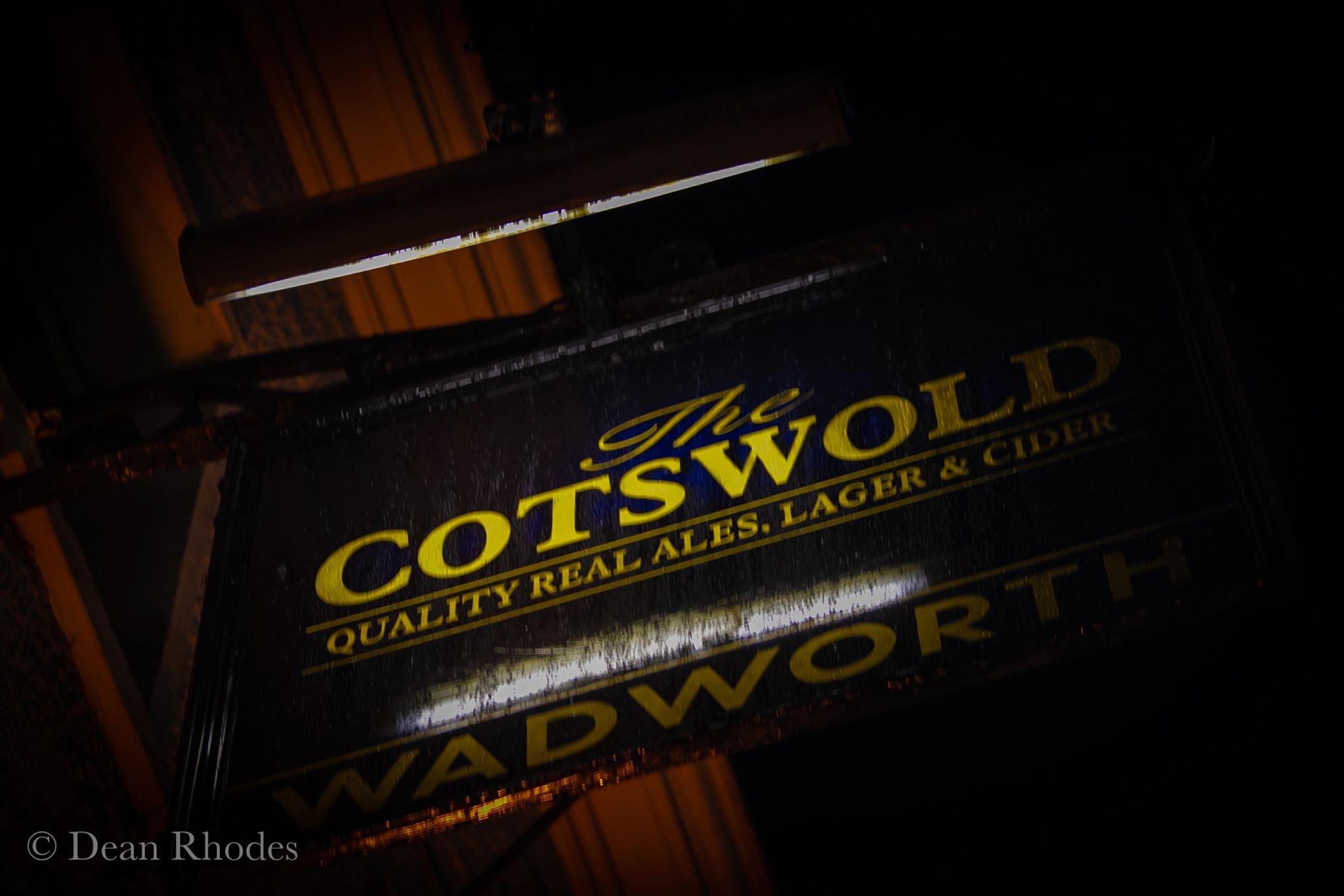 Exterior sign of The Cotswold Inn at night