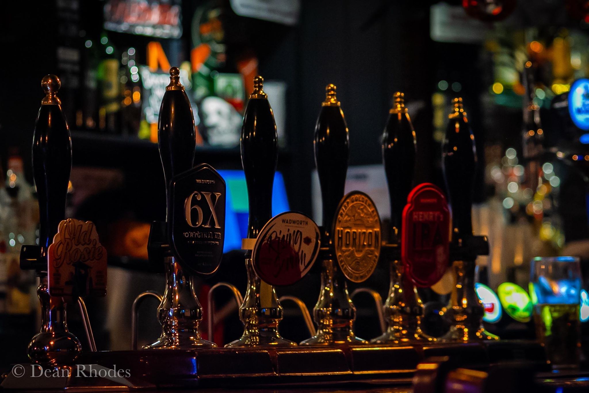 Inside The Cotswold Inn with warm lighting and the bar in view